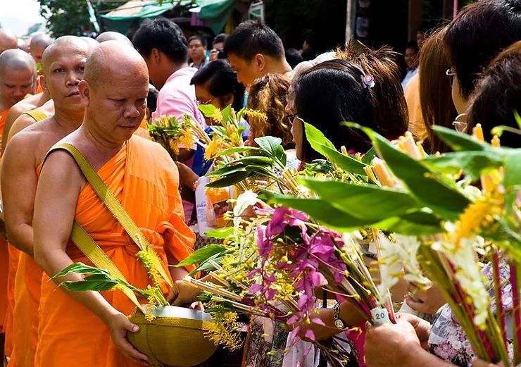 People Giving Flower to Buddhist Monk in the Middle of the City