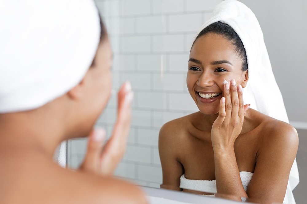 Applying skincare in-front of mirror