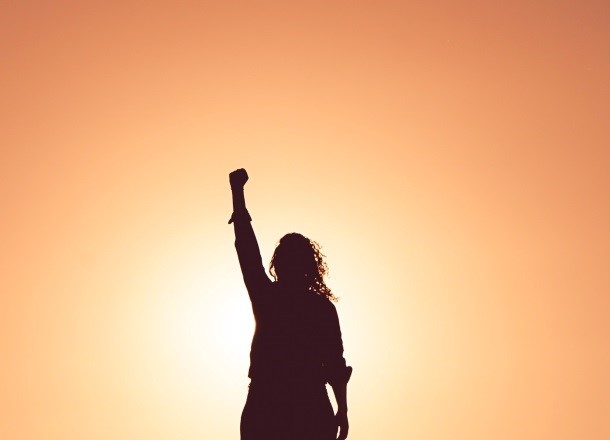 Young happy woman at sunset, silhouette of rock star pose